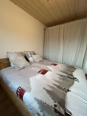 a bed with white sheets and pillows on it at Appartement Dolce Vista in Passy
