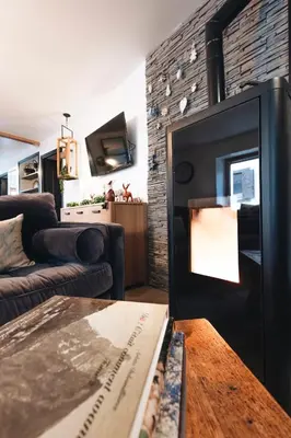 a living room with a couch and a fireplace at Design flat-center of Samoëns in Samoëns