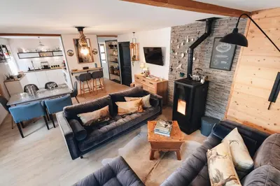 a living room with a couch and a stove at Design flat-center of Samoëns in Samoëns