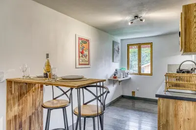 a kitchen with a counter and a table with stools at Appartement Chez Albert situé 25KM Chamonix in Saint-Gervais-les-Bains