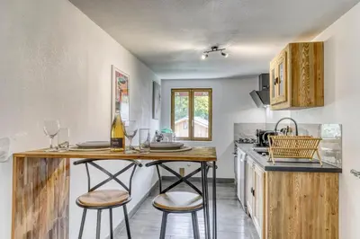 a kitchen with a table and two stools at Appartement Chez Albert situé 25KM Chamonix in Saint-Gervais-les-Bains