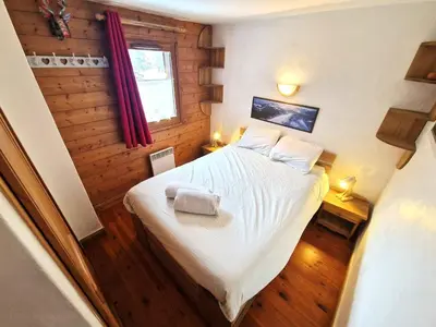 a small bedroom with a bed and a window at La Ginabelle 2 - Vue MontBlanc in Chamonix-Mont-Blanc