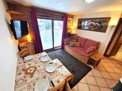a living room with a table and a couch at La Ginabelle 2 - Vue MontBlanc in Chamonix-Mont-Blanc