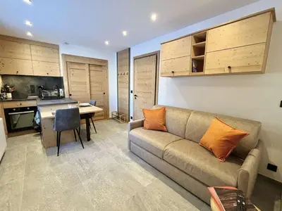 a living room with a couch and a kitchen at Studio confortable proche du centre avec parking, navette et randonnées à Megève - FR-1-597-190 in Megève