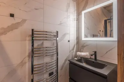 a bathroom with a sink and a mirror at Duplex des Rois - Welkeys in Megève
