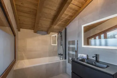 a bathroom with a sink and a bath tub at Duplex des Rois - Welkeys in Megève