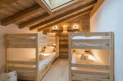 two bunk beds in a room with wooden ceilings at Duplex des Rois - Welkeys in Megève