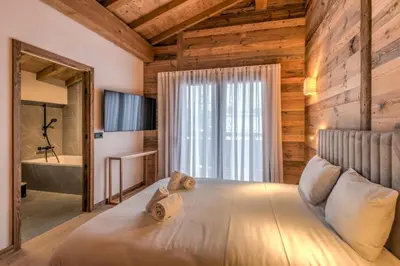 a bedroom with a large bed with a large window at Duplex des Rois - Welkeys in Megève