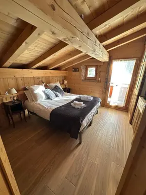 a bedroom with a bed in a wooden cabin at Chalet La Pioleute Megève in Megève