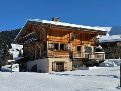 a large wooden building with snow on the ground at Chalet La Pioleute Megève in Megève