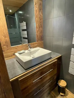 a bathroom with a white sink and a mirror at Chalet La Pioleute Megève in Megève