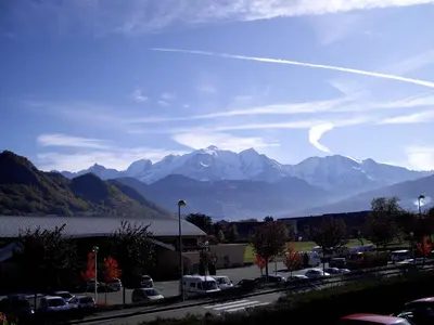 a view of a mountain range from a parking lot at Le Haut du Rosay in Sallanches