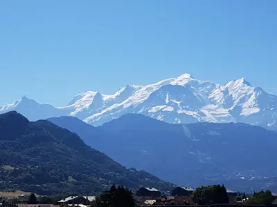a mountain range with snow capped mountains in the distance at Le Haut du Rosay in Sallanches