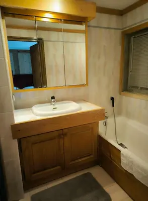 a bathroom with a sink and a mirror and a tub at Apartment in residence near the Mont d'Arbois in Megève