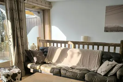 a leather couch sitting in a room with a window at Apartment in residence near the Mont d'Arbois in Megève