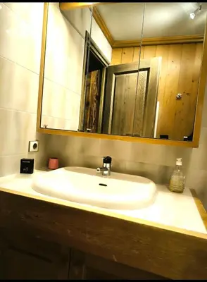 a bathroom with a white sink and a mirror at Apartment in residence near the Mont d'Arbois in Megève