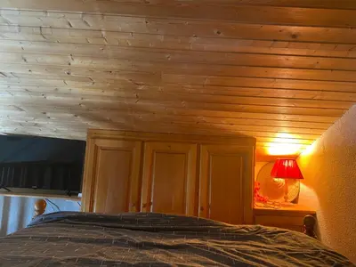 a bedroom with a bed with a wooden ceiling at Les blanches aiguilles in Les Carroz d'Araches