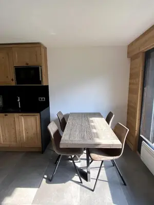 a table and chairs in a room with a kitchen at Le Nid Douillet des Gerets in Saint-Gervais-les-Bains