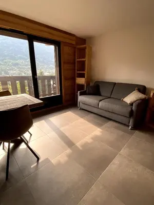 a living room with a couch and a table at Le Nid Douillet des Gerets in Saint-Gervais-les-Bains