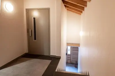 a hallway with a door in a building at Les Couadzous Samoëns Centre, Sauna, Jacuzzi, 6 chambres, 7 salles de bains, 16 pers 250 m2 in Samoëns