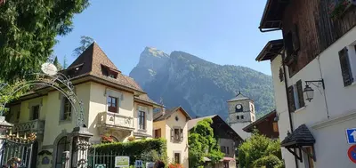 a street with buildings and a mountain in the background at Les Couadzous Samoëns Centre, Sauna, Jacuzzi, 6 chambres, 7 salles de bains, 16 pers 250 m2 in Samoëns