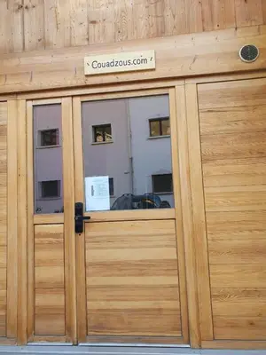 a wooden garage door with a sign on it at Les Couadzous Samoëns Centre, Sauna, Jacuzzi, 6 chambres, 7 salles de bains, 16 pers 250 m2 in Samoëns