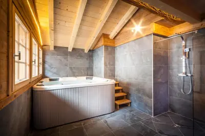 a bathroom with a tub and a shower at Les Couadzous Samoëns Centre, Sauna, Jacuzzi, 6 chambres, 7 salles de bains, 16 pers 250 m2 in Samoëns
