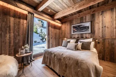 a bedroom with wooden walls and a bed with a window at Chalet Betula, Saint-Gervais - by EMERALD STAY in Saint-Gervais-les-Bains