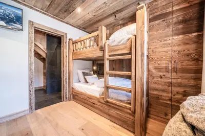 a bedroom with bunk beds in a room with wooden walls at Chalet Betula, Saint-Gervais - by EMERALD STAY in Saint-Gervais-les-Bains