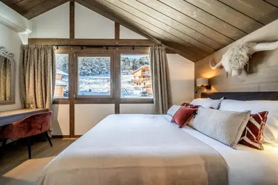 a bedroom with a large bed and a window at Chalet Luluvert, Saint-Gervais - by EMERALD STAY in Saint-Gervais-les-Bains