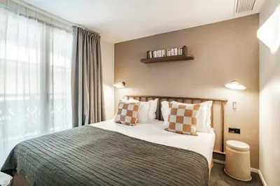 a bedroom with a bed and a large window at Appartements de l'Héliopic in Chamonix-Mont-Blanc