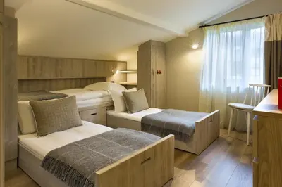 a hotel room with two beds and a window at Appartements de l'Héliopic in Chamonix-Mont-Blanc