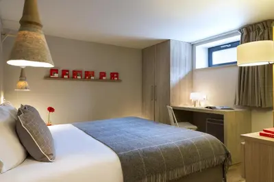 a bedroom with a bed and a desk and a window at Appartements de l'Héliopic in Chamonix-Mont-Blanc