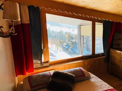 a bedroom with a window with a view of a snow covered yard at Superbe duplex with Hammam-Spa in Megève in Megève