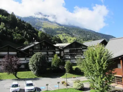 a hotel in the mountains with cars parked in a parking lot at Résidence Combettes - Combettes E288 MAE-5071 in Les Contamines-Montjoie