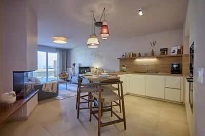 a kitchen with a table and chairs in a room at Le Miroir De Saint-Jacques in Sallanches