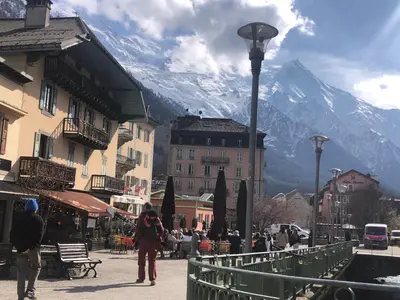 a group of people walking down a street with a mountain at Chez Sab in Passy