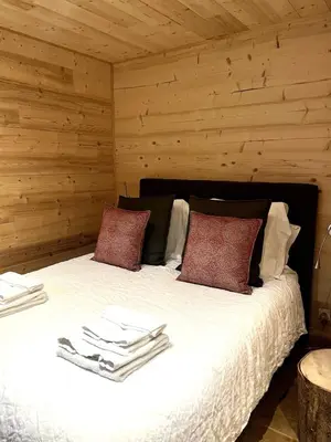 a bedroom with a large bed with wooden walls at Chalet Nuances certifié 5 étoiles in Les Contamines-Montjoie