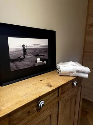 a flat screen tv sitting on top of a wooden dresser at Chalet Nuances certifié 5 étoiles in Les Contamines-Montjoie