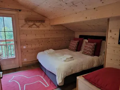 a bedroom with a bed in a log cabin at Chalet Nuances certifié 5 étoiles in Les Contamines-Montjoie