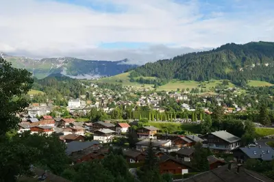 a town in the mountains with houses and trees at Sumptuous chalet with breathtaking mountain views in Megève