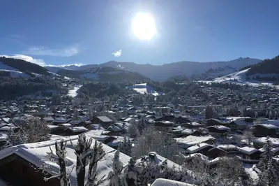 a city covered in snow with the sun in the background at Sumptuous chalet with breathtaking mountain views in Megève