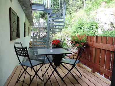 a patio with a table and two chairs on a deck at Le Dahu in Chamonix-Mont-Blanc