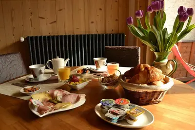 a table with food and drinks and flowers on it at Le Dahu in Chamonix-Mont-Blanc