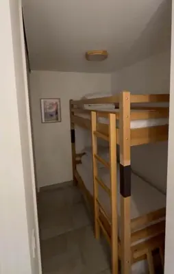 a couple of bunk beds in a small room at Appartement neuf tout confort super emplacement in Samoëns