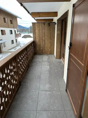 a walkway leading to a door on a balcony at Appartement neuf tout confort super emplacement in Samoëns