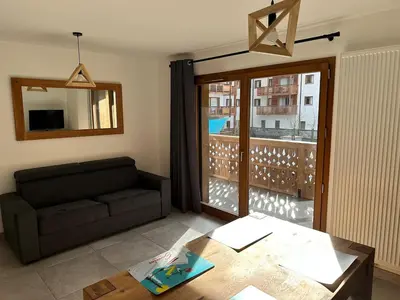 a living room with a couch and a table at Appartement neuf tout confort super emplacement in Samoëns