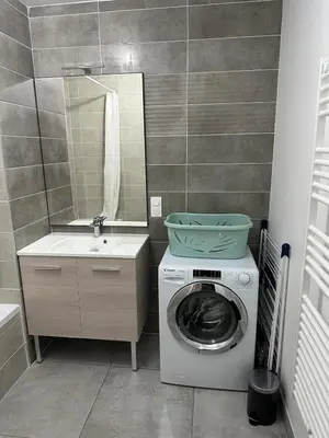 a bathroom with a washing machine and a sink at Appartement neuf tout confort super emplacement in Samoëns