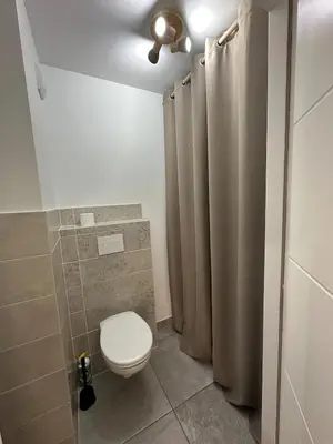 a bathroom with a toilet and a shower curtain at Appartement neuf tout confort super emplacement in Samoëns