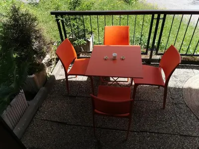 two orange chairs and a table on a balcony at le Nid Douillet au pied de Megève in Demi-Quartier
